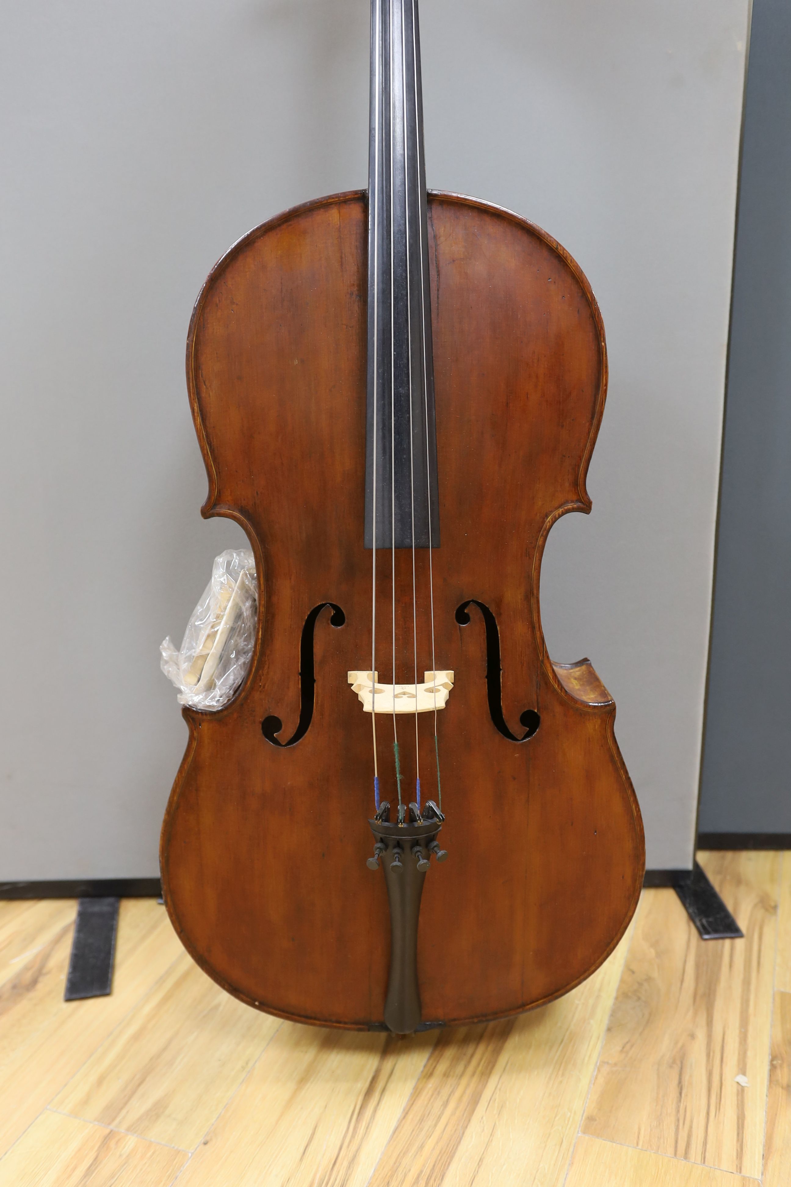 A cased early 20th century ‘cello, length of body 75.5cm, with two spare bridges, and spare strings